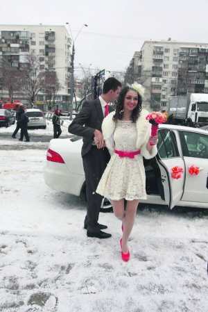 Наречені Христина та Олександр Віники виходять з машини перед Центральним РАЦСом у Києві. Вони єдині приїхали розписатися на святково вбраній машині і у весільному одягу