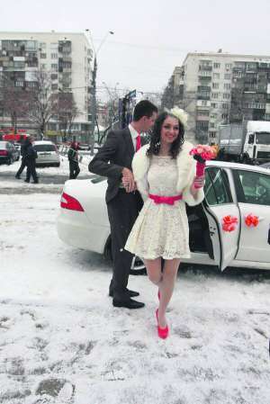 Наречені Христина та Олександр Віники виходять з машини перед Центральним РАЦСом у Києві. Вони єдині приїхали розписатися на святково вбраній машині і у весільному одягу