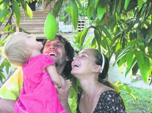Тетяна й Андрій Борисови з донькою Анет стоять під деревом манго біля свого дому у джунглях Бейлізу. Вони переїхали туди жити із Казахстану