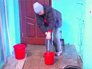 Жителька будинку №36 на вулиці Богдана Хмельницького в Полтаві 26 грудня ганчіркою витирає воду в під’їзді. Сім годин так із сусідами прибирали
