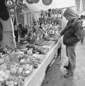 Турист розглядає дерев’яні шкатулки на ринку Вернісаж на вулиці Театральній у Львові. Сувенірний ринок діє тут із 1992 року