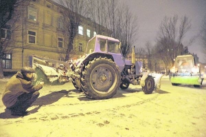 Водій оглядає трактор на площі Старий Ринок у ніч з 11 на 12 січня. Напередодні майже не сніжило, але комунальники все одно розчищали дороги цілу ніч