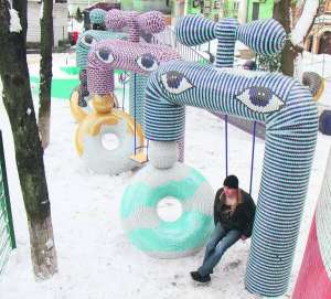 14 січня на Пейзажній алеї у Києві будівельник дитячого майданчику  відпочиває на гойдалці. Її підвісили до скульптури ”Кран достатку”