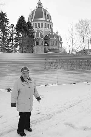 Тернополянка Ольга Дзюбановська показує паркан, яким обгородили ділянку церковної землі на вулиці Гетьмана Орлика, 1а. Там, між недобудованою церквою і сусіднім домом, планують звести багатоповерхівку