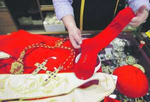 Кравець тримає червону шкарпетку для майбутнього Папи Римського. Кілька тижнів головні майстерні Рима з пошиття одягу для священнослужителів готують убрання для нового глави римо-католицької церкви