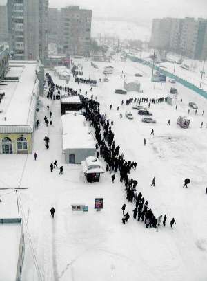 У п’ятницю зранку у Львові на проспекті Червоної Калини люди чекають на транспорт. Через снігопад маршрутки не виїхали з автопарку або застряли в заметах. Більшість жителів повернулися додому, не вийшли на роботу