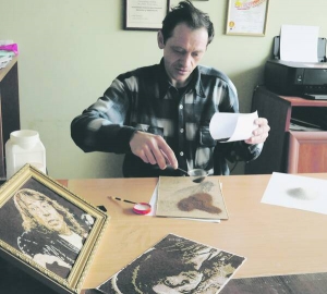 Львів’янин Олександр Вальд у майстерні посипає меленою кавою змащений клеєм малюнок. На картину йде півчашки кавової гущі сорту робуста чи арабіка