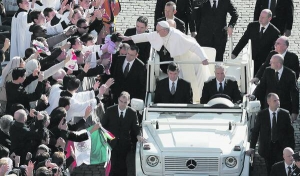 Папа Франциск І торкається голови дитини, благословляє її на площі Святого Петра у Ватикані під час інтронізаційної церемонії 19 березня