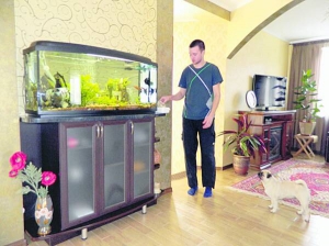 Син Володимира Постового Павло годує рибок у вітальні. Родина голови сільради Агрономічного тримає ще двох собак та кішку