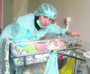 Олена Юрченко схиляється над новонародженим сином Євгеном у Донецькій обласній лікарні. Хлопчик вісім днів був у комі, пережив клінічну смерть. Немовля готові оперувати німецькі лікарі 