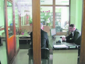 Заступник начальника жеку №15 Василь Чернюк (праворуч) приймає відвідувачів у кабінеті з прозорими стінами