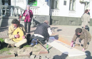 Полтавські митці на акції протесту малюють плакат з вимогою прибрати нову кав’ярню на вулиці Жовтневій 