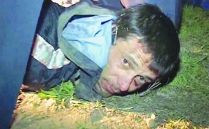 Сергій Помазун лежить обличчям донизу в наручниках після того, як у вівторок його заарештували за вбивство шістьох людей у місті Білгород