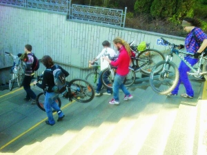 Велосипедисти спускаються до столичного метро Поштова площа 23 квітня, тримаючи свій транспорт. Нарікають на закруті сходи та завузькі пандуси