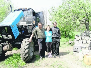 Анатолій Пономаренко з дружиною Луїзою Дрангою і сином Андрієм біля свого трактора у селі Великодрюкове на Кіровоградщині. Торік вони поховали останнього односельця. За часів незалежності з карти України зникли 40 селищ і 601 село