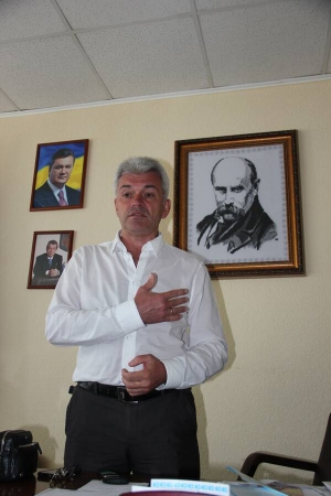 Мер Канева Віктор Ніколенко стоїть за робочим столом у своєму кабінеті. Позаду нього вишитий портрет Тараса Шевченка, який зробила місцева майстриня. У кабінеті зберігає чимало ікон, ексклюзивне видання ”Кобзаря” та ”Біблію”. Коли прийшов на посаду, ремонт не робив