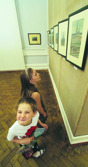 Дві дівчинки прийшли на відкриття виставки лемківського художника-примітивіста Никифора. На його малюнках — церкви, палаци та пейзажі Бескид