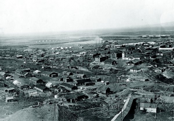 Селищу Норильськ 1953 року, коли зроблено цей знімок, надано статус міста. Розташоване за Полярним колом, нижче Таймирського півострова, морози тут тривають 280 днів на рік. Одне з найхолодніших міст у світі, температура може опускатися до мінус 60 градусів. Засноване 1935го для розробки місцевих покладів міднонікелевих руд і спорудження металургійного комбінату. Робоча сила й основне населення до середини 1950х – в’язні ҐУЛАҐу. Того ж 1953го Норильський комбінат передали з Міністерства внутрішніх справ у відомство Міністерства металургії СРСР