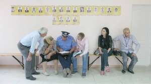  Міліціонер складає протокол про порушення на дільниці №73 під час виборів мера Василькова на Київщині. Там жінка, що сидить ліворуч, не змогла проголосувати, бо замість неї це зробив хтось інший. 2 червня