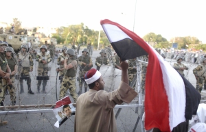 Прихильник поваленого президента Мухаммеда Мурсі тримає єгипетський прапор перед солдатами. Каїр, 7 липня 2013 року