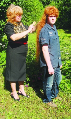 Мати Артура Покоса з Дрогобича на Львівщині розчісує синові волосся. Воно сягає 1,12 метра завдовжки