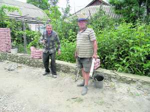 Жителі Городківки Крижопільського району Анатолій Брунько (праворуч) та Борис Крупкій роблять паркан сусідці Олені Бойко. Чоловіки підробляють будівельними роботами по селу. Жінка каже, що працюють повільно, але беруть за роботу дешевше — по 100 гривень. Інші просять 150