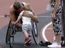 Британец Дэвид Вейр обнимает сына Мейсона после победы в заезде на легкоатлетических соревнованиях в Лондоне