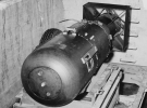 «Малыш» покоится на трейлере в яме над шлюзом бомбардировщика B-29 Superfortress &quot;Enola Gay&quot; на базе 509-ой сводной группы на Марианских островах в 1945 году. «Малыш» составлял 3 м в длину и весил 4 000 кг, но содержал всего 64 кг урана, который использовался для провоцирования цепочки атомных реакций и последующего взрыва. (U.S. National Archives)