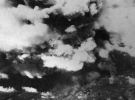 Фото, сделанное из одного из двух американских бомбардировщиков 509-ой сводной группы, вскоре после 8:15, 5 августа 1945 года, показывает поднимающийся от взрыва дым над городом Хиросима. К моменту съемки уже произошла вспышка света и жара от огненного шара диаметром 370 м, и взрывная волна, движущаяся со скоростью света, быстро рассеивалась, уже причинив основной вред зданиям и людям в радиусе 3,2 км. (U.S. National Archives)