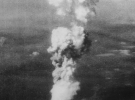 Зростаючий ядерний «гриб» над Хіросімою незабаром після 8:15, 5 серпня 1945 року. Коли порція урану в бомбі пройшла стадію розщеплення, вона миттєво була перетворена в енергію 15 кілотонн тротилу, нагрівши масивну вогненну кулю до температури 3980 градусів за Цельсієм. Нагріті до межі повітря та дим швидко піднялися в атмосфері, немов величезний міхур, піднімаючи за собою стовп диму