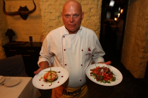 Шеф-кухар столичного ресторану ”Казбек” Юрій Матузка тримає запечені з курятиною баклажани у правій руці, салат по-гурійському — в лівій. Готувати ці страви вчився у Грузії