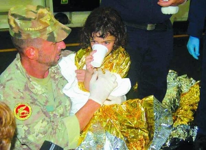 Італійський солдат дає води дівчинці, яку евакуювали з Сирії. 28 серпня 2013 року корабель із групою біженців прибув із Сирії на острів Сицилія в Італії