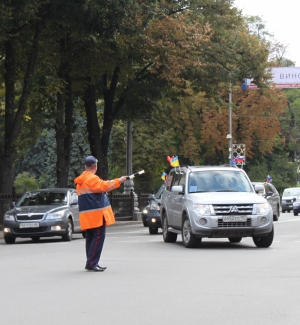 Даїшник направляє машини з російськими номерами в бік вулиці Шовковичної у Києві. Три такі авто їздили 2 вересня біля Верховної Ради із прапорцями Росії та України — агітували за вступ у Митний союз. Поряд близько півтисячі людей мітингували за вступ України до Євросоюзу