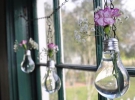 Если приготовленные лампочки прикрепить к цепи с крючками для подвешивания, то останется только налить в них воду и поставить букетики цветов. 