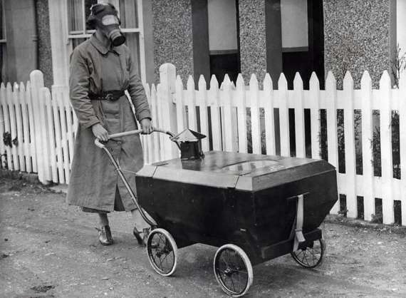 Женщина с коляской, оборудованной против газовых атак. Англия, 1938 год.