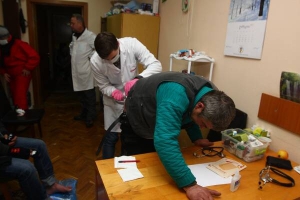 Лікар Ілля робить укол чоловікові у медичному пункті, що на другому поверсі КМДА. Тут він прий­має хворих уже другий тиждень