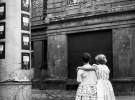 Две девочки на улице Западной Германии разговаривают со своими бабушкой и дедушкой в окне дома в восточной зоне, отделенной баррикадой из колючей проволоки, 14 августа 1961 года