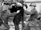 Умирающего Питера Фехтера уносят солдаты пограничной службы Восточной Германии, которые стреляли в него, когда тот пытался бежать на запад 17 августа 1962 года