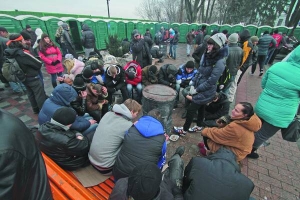 Учасники акції на підтримку влади в Маріїнському парку гріються навколо діжки з вогнищем. Партія регіонів на дводенний мітинг до Києва звезла своїх прихильників зі східних областей України