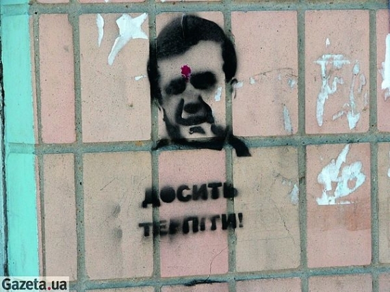 У графіті, що зображує голову чоловіка з червоною цяткою на лобі, українські правоохоронці розгледіли портретну схожість із президентом Віктором Януковичем. Цятку потрактували як кривавий слід від пострілу