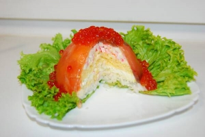 Салат із червоної риби розрізають, як торт. Подають одразу після приготування, бо ікра швидко обвітрюється