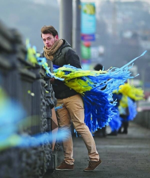 Чоловік прикрашає столичний міст Патона через Дніпро жовтими та синіми стрічками. Близько 30 активістів Майдану кілька годин обвішували поручні національною символікою, щоб привернути увагу водіїв до акцій протесту