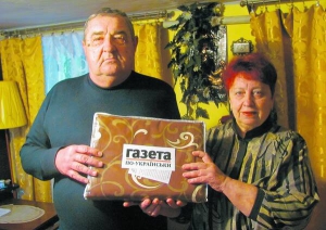 Подружжя Кравчуків тримають постільну білизну, яку одержали в подарунок від ”Газети по-­українськи”