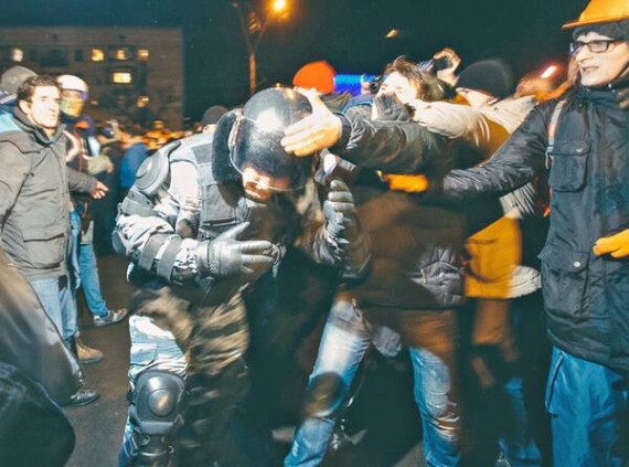Громадські активісти знімають шоломи з бійців міліцейського спецпідрозділу ”Беркут” уночі 11 січня біля Святошинського райвідділу міліції Києва