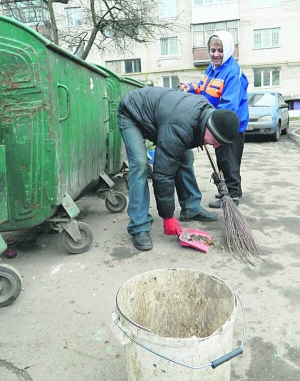 Тетяна Лукіяніц прибирає біля сміттєвих контейнерів у дворі багатоповерхівки на вулиці Рєпіна у Вінниці. Їй допомагає цивільний чоловік Олег Чхаїдзе