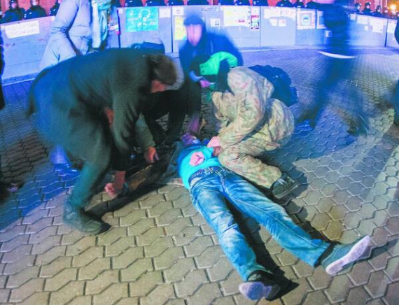 Люди допомагають протестувальникові після силового розгону Євромайдану вранці 30 листопада 2013-го. ”Беркутівці” застосували кийки та світло-шумові гранати. Били жінок та літніх людей
