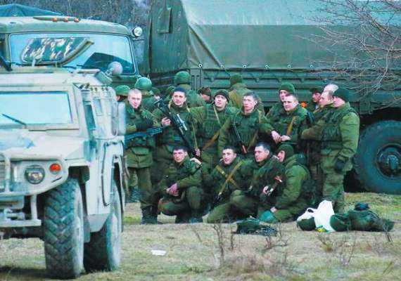 Озброєні люди, найімовірніше російські солдати, позують для групової фотографії біля української військової бази в Перевальному поблизу Сімферополя.  5 березня 2014 року