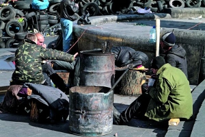 foto1: Чоловіки із самооборони Майдану гріються біля бочок у наметовому містечку в центрі Києва. Майдан Незалежності,  18 березня 2014 року  