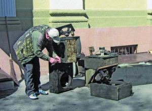 Працівник полтавського театру імені Гоголя біля приміщення чистить від сажі музичні колонки. Пожежа 26 березня знищила музичну та світлову техніку, її неможливо відновити