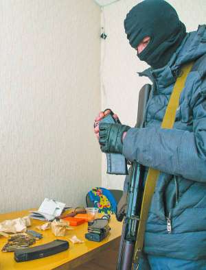 Проросійський активіст заряджає автомат Калашникова у приміщенні Служби безпеки в Луганську, яке захопили сепаратисти